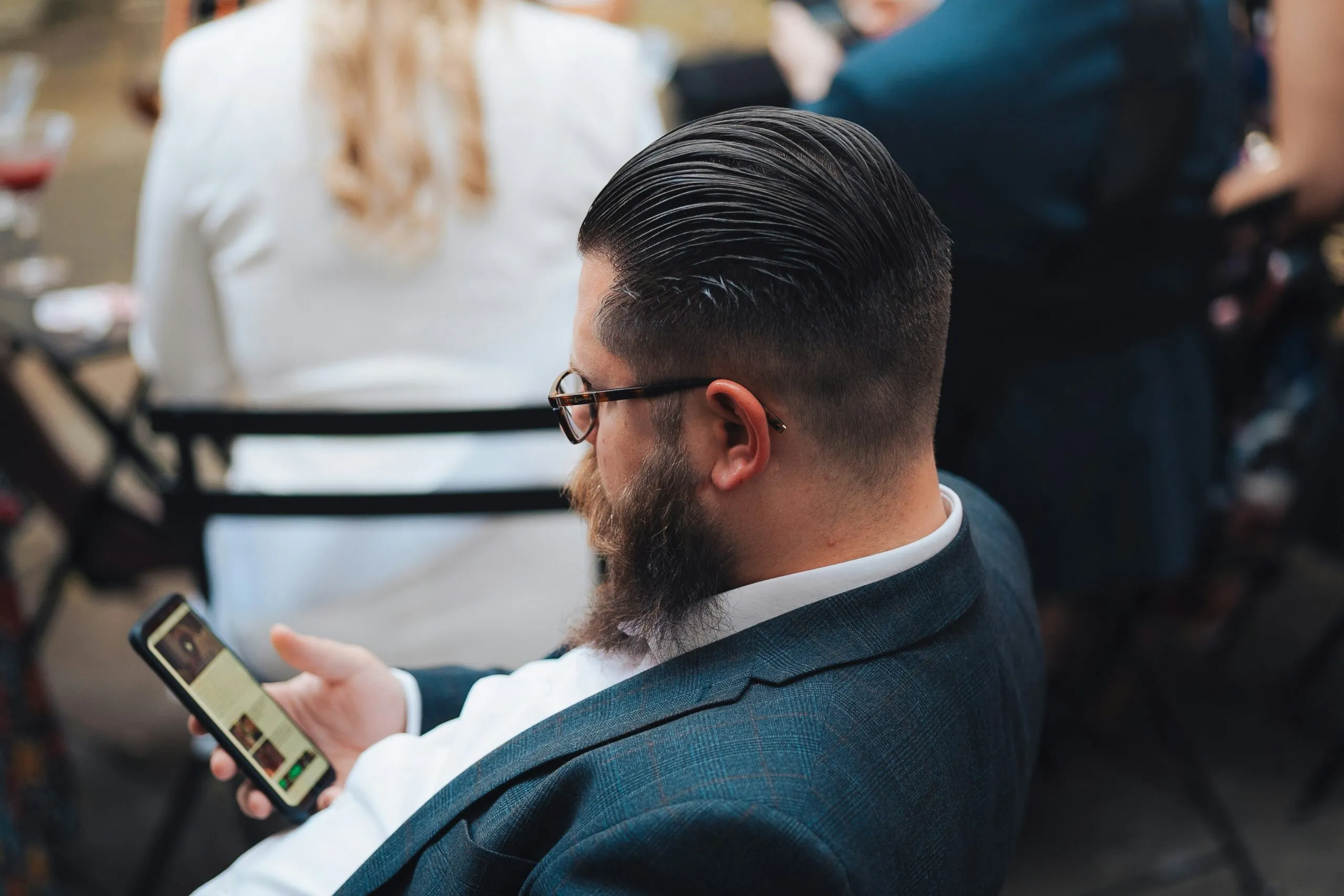 a man sitting in a chair looking at his cell phone